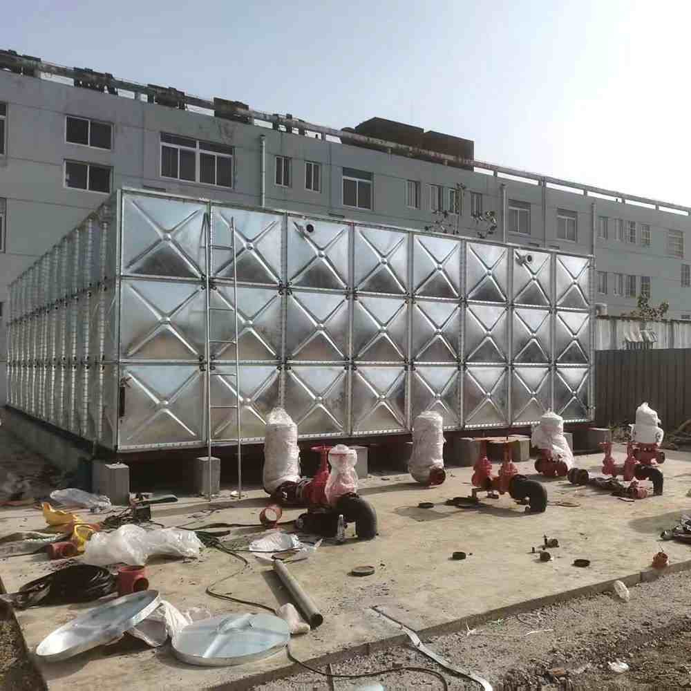 Industrial water treatment tanks with ladders under clear blue sky