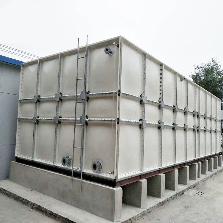 Industrial water storage tanks with ladders and pipe connections under blue sky — SMC modular panel tank application
